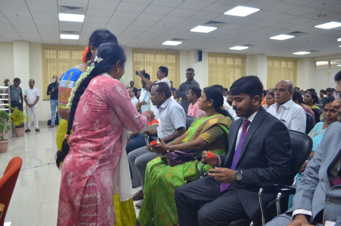 A young girl being felicitated with a garland at a community programme