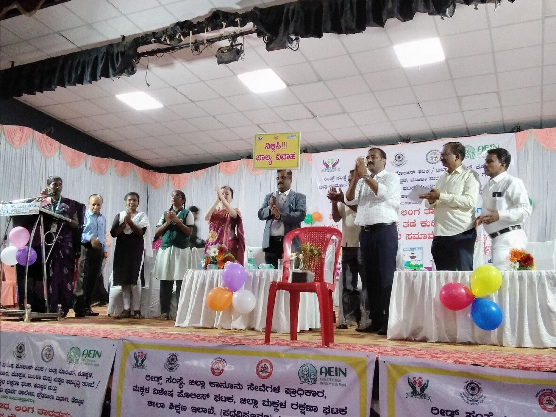 Officials applauding on stage at a Jatha programme against child marriage